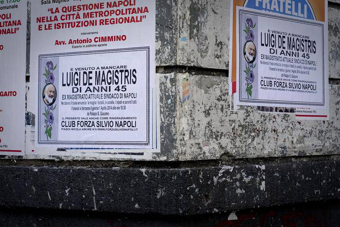 I manifesti che annunciano la morte di Luigi de Magistris (Foto Ansa.it)