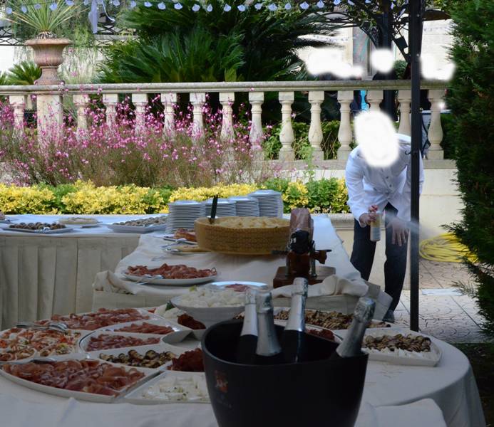 Insetticida sul buffet di nozze, cameriere fotografato mentre spruzza lo spray