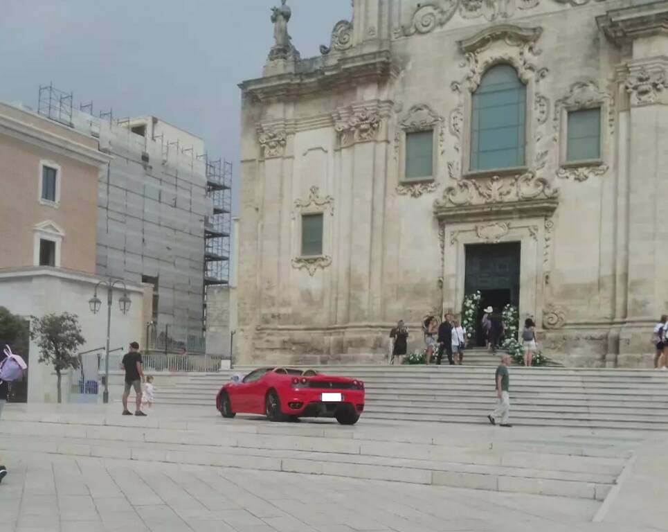 Ferrari parcheggiata sul sagrato della chiesa