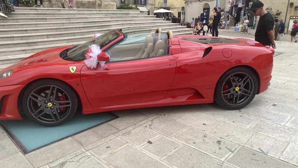Ferrari parcheggiata sul sagrato della chiesa